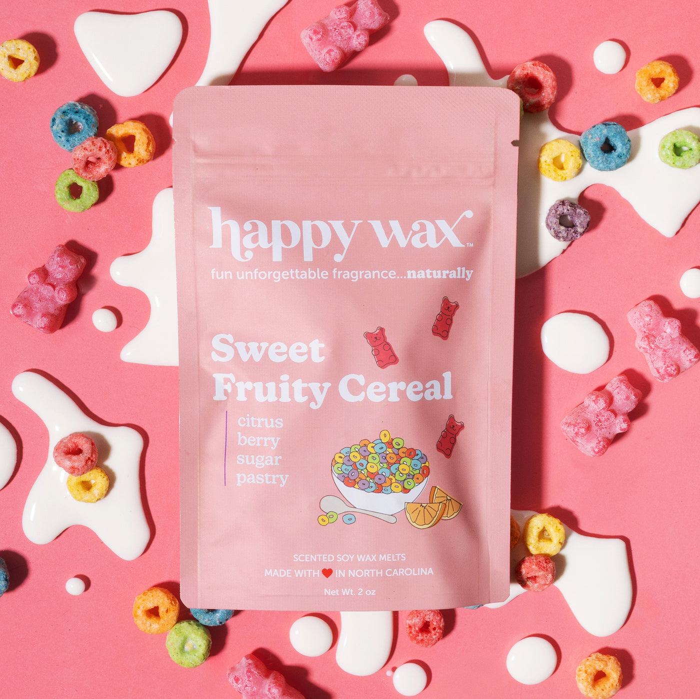 Pink wax melt package labeled "Sweet Fruity Cereal" surrounded by colorful cereal rings and white shapes on pink background.