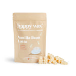 Beige pouch labeled "happy wax Vanilla Bean Latte" with cream and orange wax melts scattered in front.