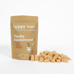 Tan kraft pouch labeled "happy wax Vanilla Sandalwood" with scattered cream-colored wax melts beside it.