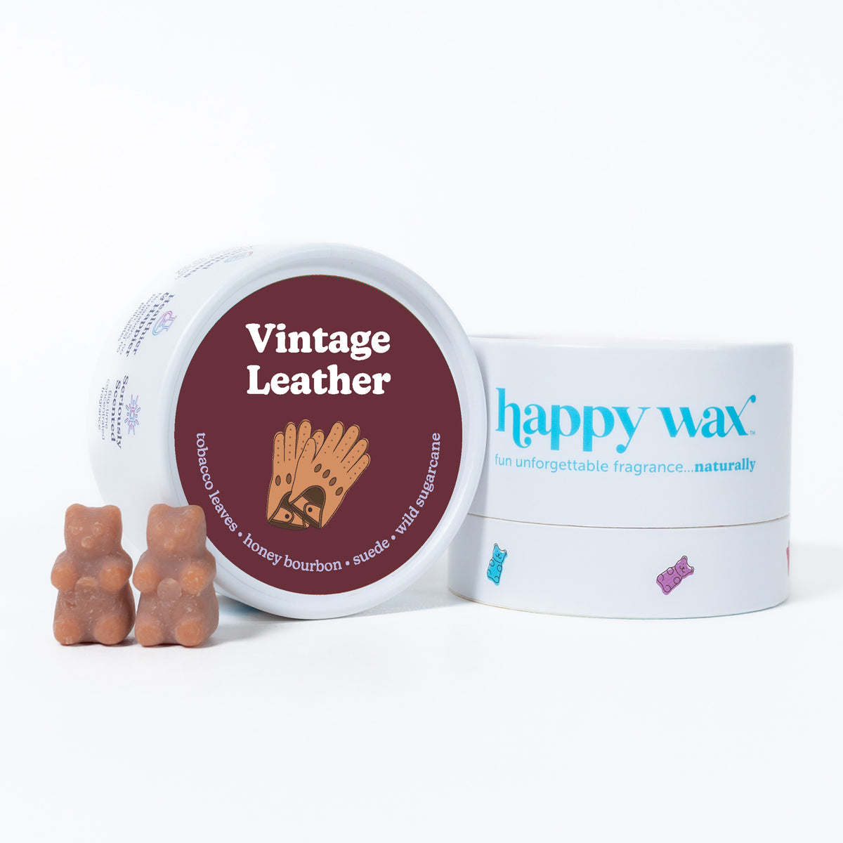Two amber bear-shaped wax melts next to a burgundy and white tin labeled "Vintage Leather" and a white "happy wax" container.