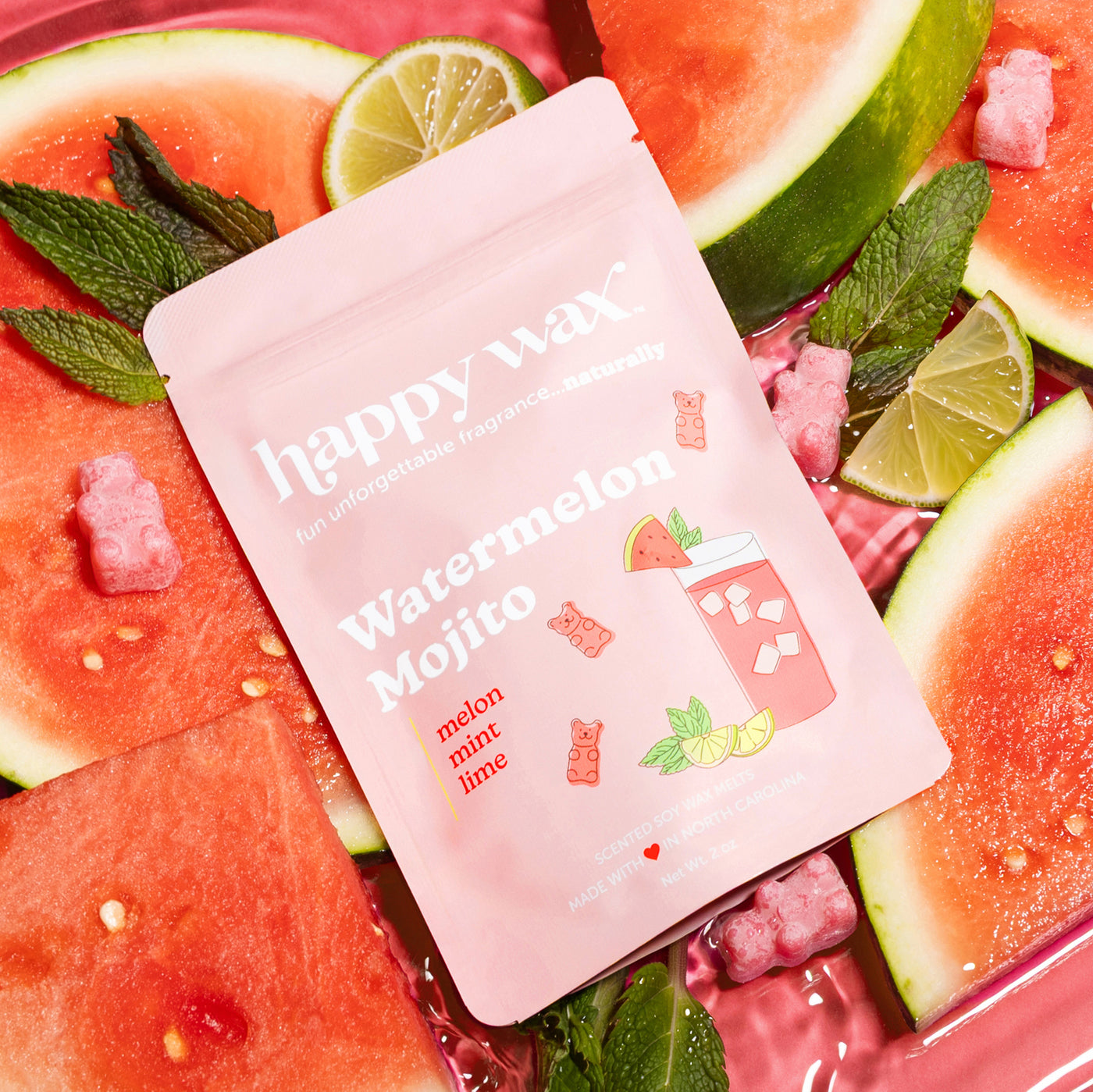 Pink pouch of wax melts surrounded by watermelon slices, lime wedges, mint leaves, and pink wax melt pieces.