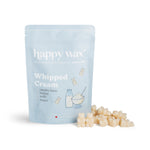 Light blue pouch of Happy Wax whipped cream wax melts with cream-colored wax pieces scattered in front.