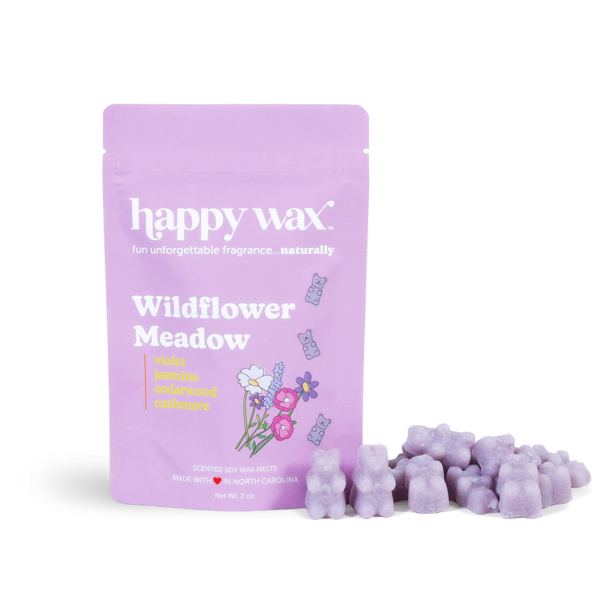 Purple pouch of Happy Wax Wildflower Meadow wax melts with scattered lavender-colored wax cubes beside it.