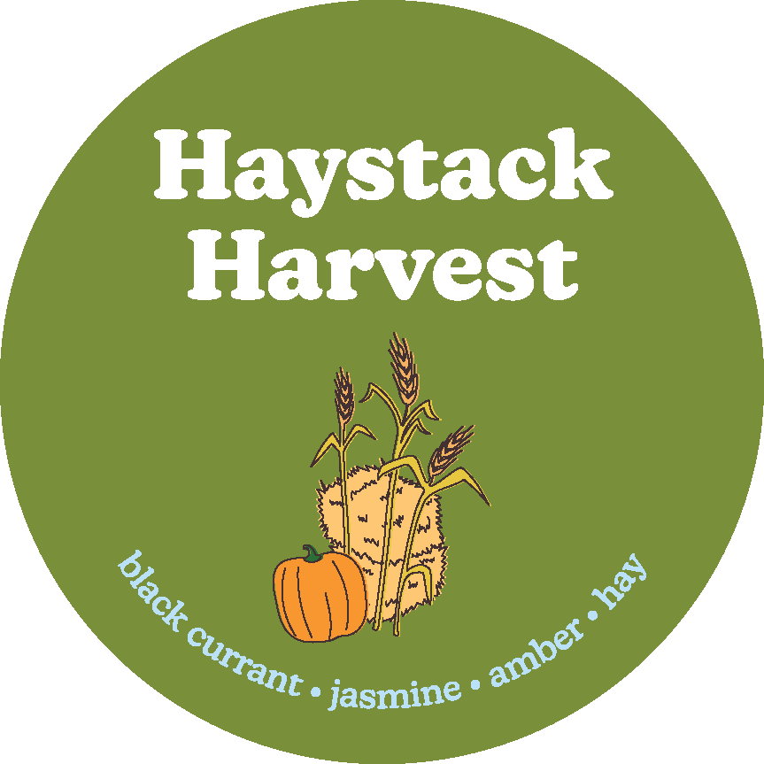 Round olive green label with "Haystack Harvest" text, wheat stalks, pumpkin, and hay illustration.