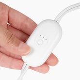 White power cord with control base held in hand, featuring power button and indicator lights.
