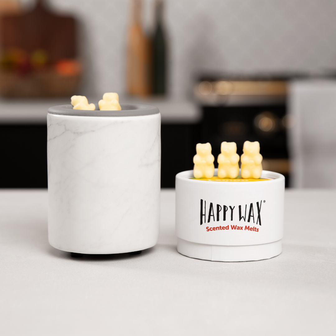 White marble cylindrical wax warmer with gray top next to Happy Wax scented wax melts container.